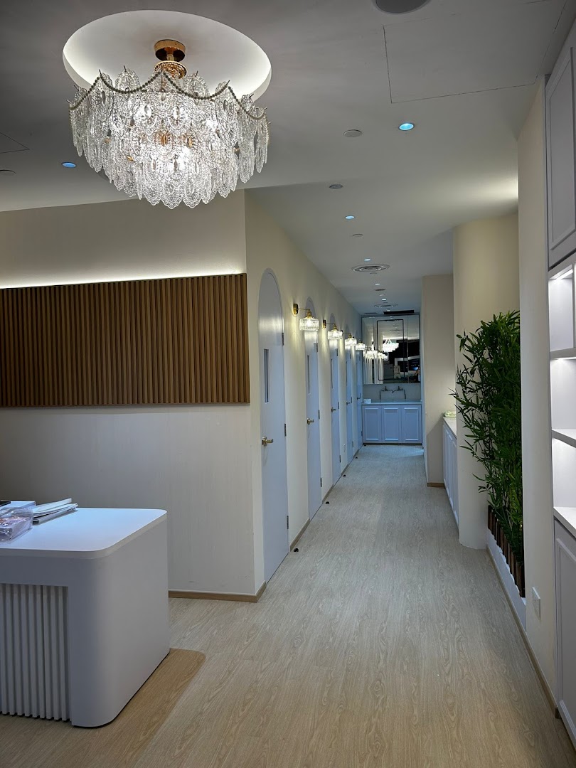 Interior hallway with multiple doors, a chandelier, and a reception desk.