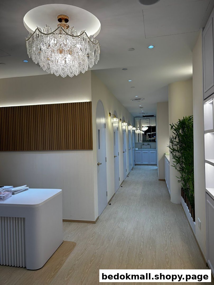 Interior hallway with multiple doors, a chandelier, and a reception desk.