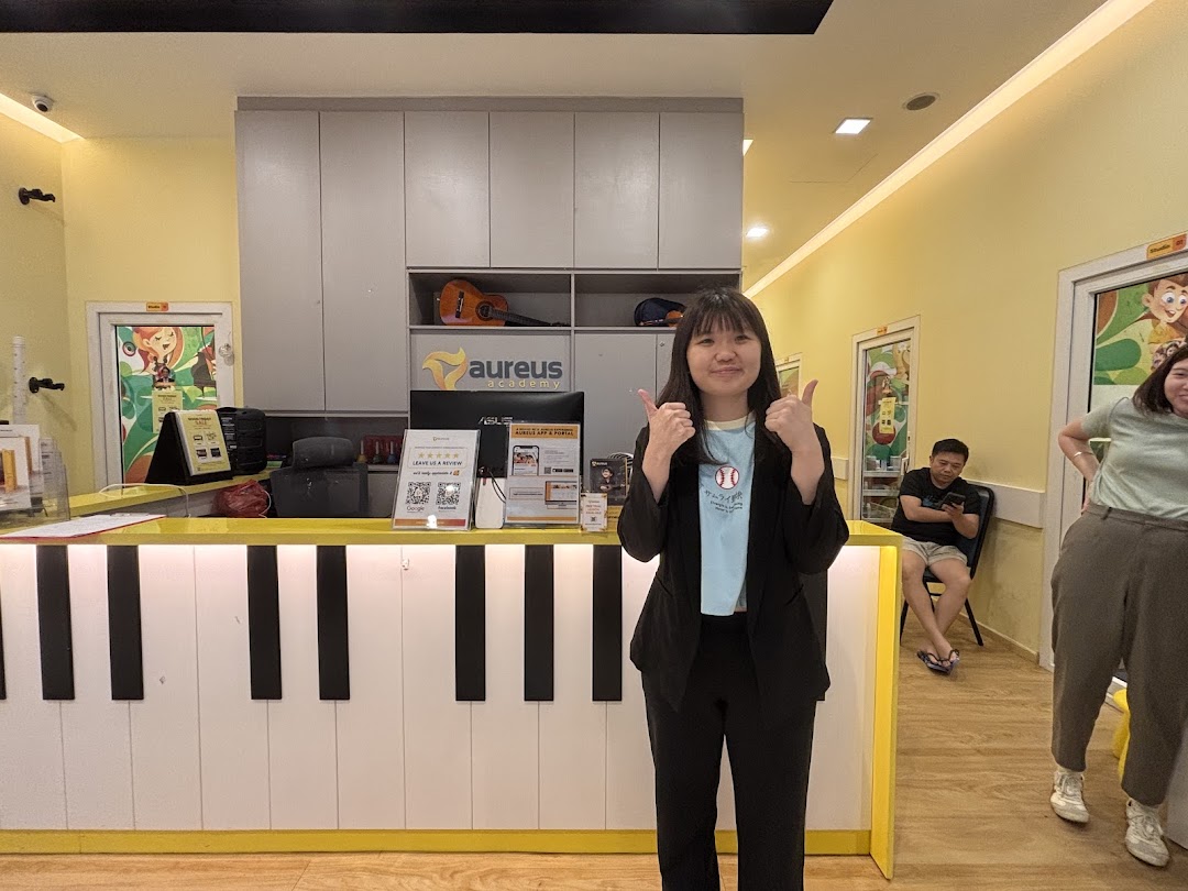 Interior shot of Aureus Academy with a piano-themed reception desk and people.