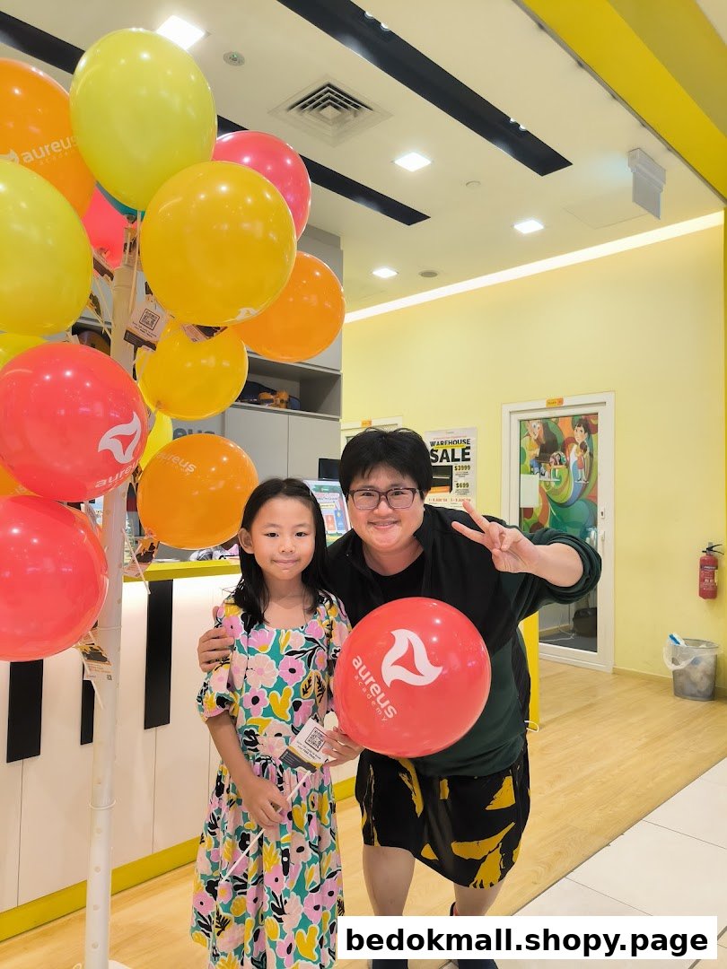 Two people pose with balloons inside Aureus Academy.