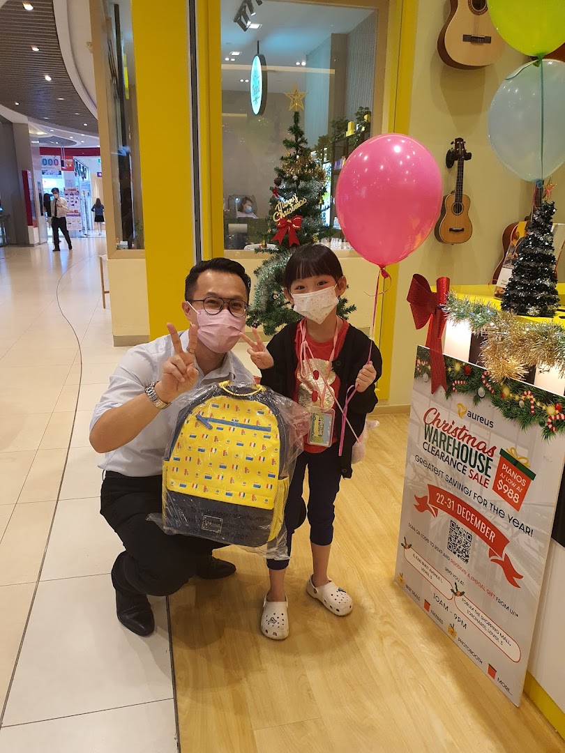 Adult and child with backpack and balloon in front of Aureus Academy.