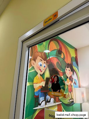 A colorful studio door with cartoon decals and a teacher's cutout.
