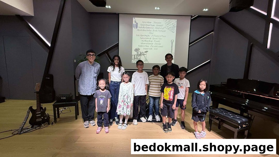 Group of people with musical instruments and a projector screen in a studio.