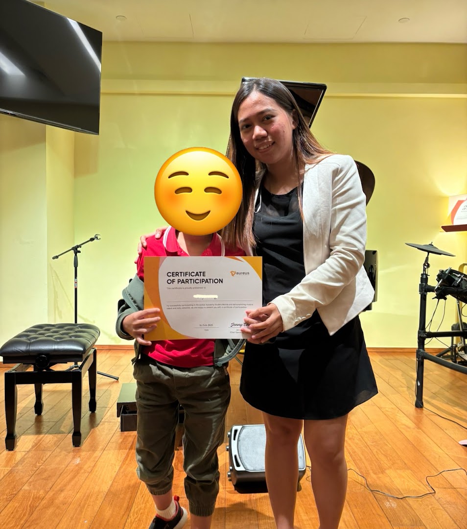 Two people holding a certificate in a music room setting.