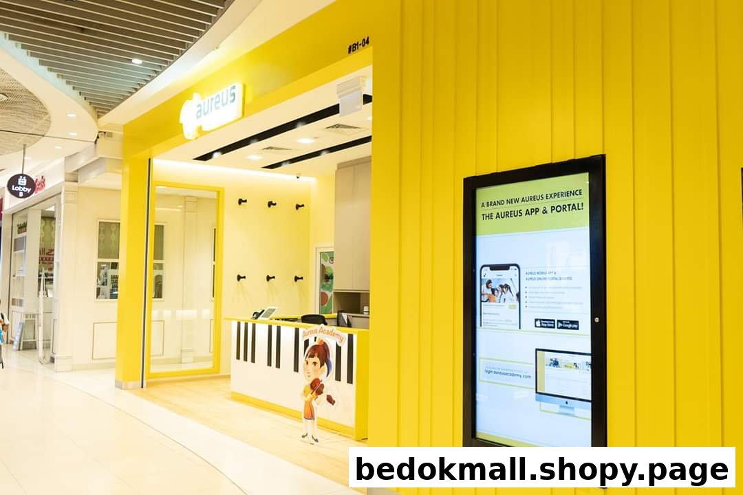 Bright yellow music academy shop front with reception desk and digital display.