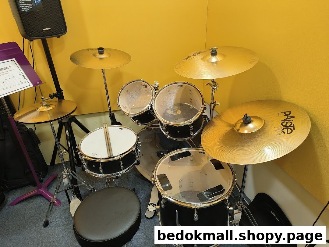 A black drum set with cymbals and a music stand in a yellow room.