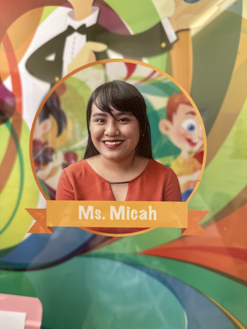 A smiling woman's photo labeled 'Ms. Micah' on a colorful background.