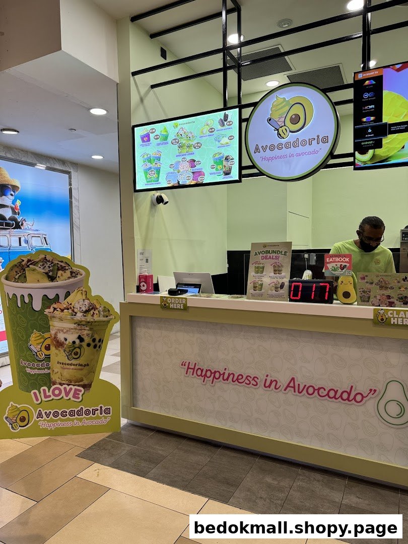 Shop counter with staff, digital menus, and branding for Avocadoria.