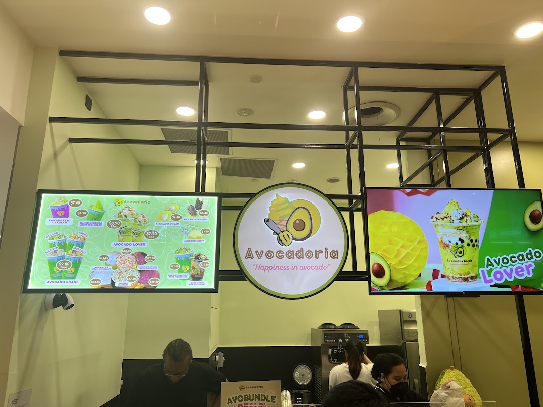 Interior view of Avocadoria shop with digital menus, counter, and staff.
