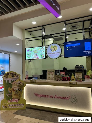 Avocadoria shop counter with menu screen, branding, and a product standee.