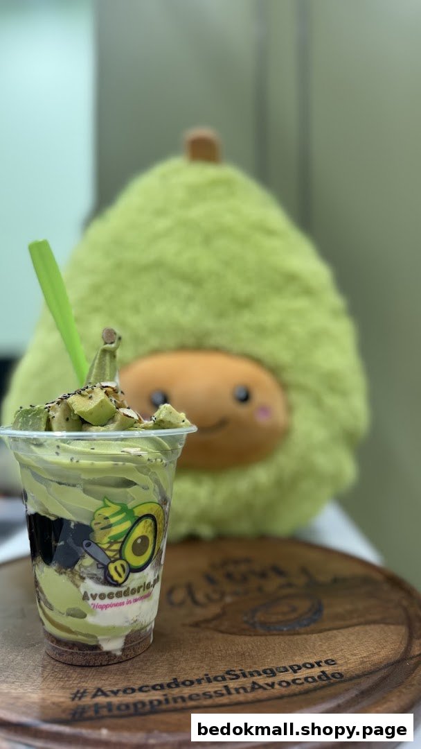 Avocado dessert cup with a green plush avocado toy in the background.