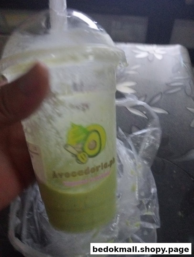 Close-up of a hand holding an avocado drink from Avocadoria.