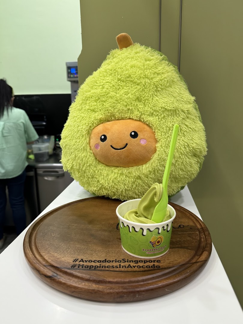Avocado plushie and soft serve cup on a wooden tray inside the shop.