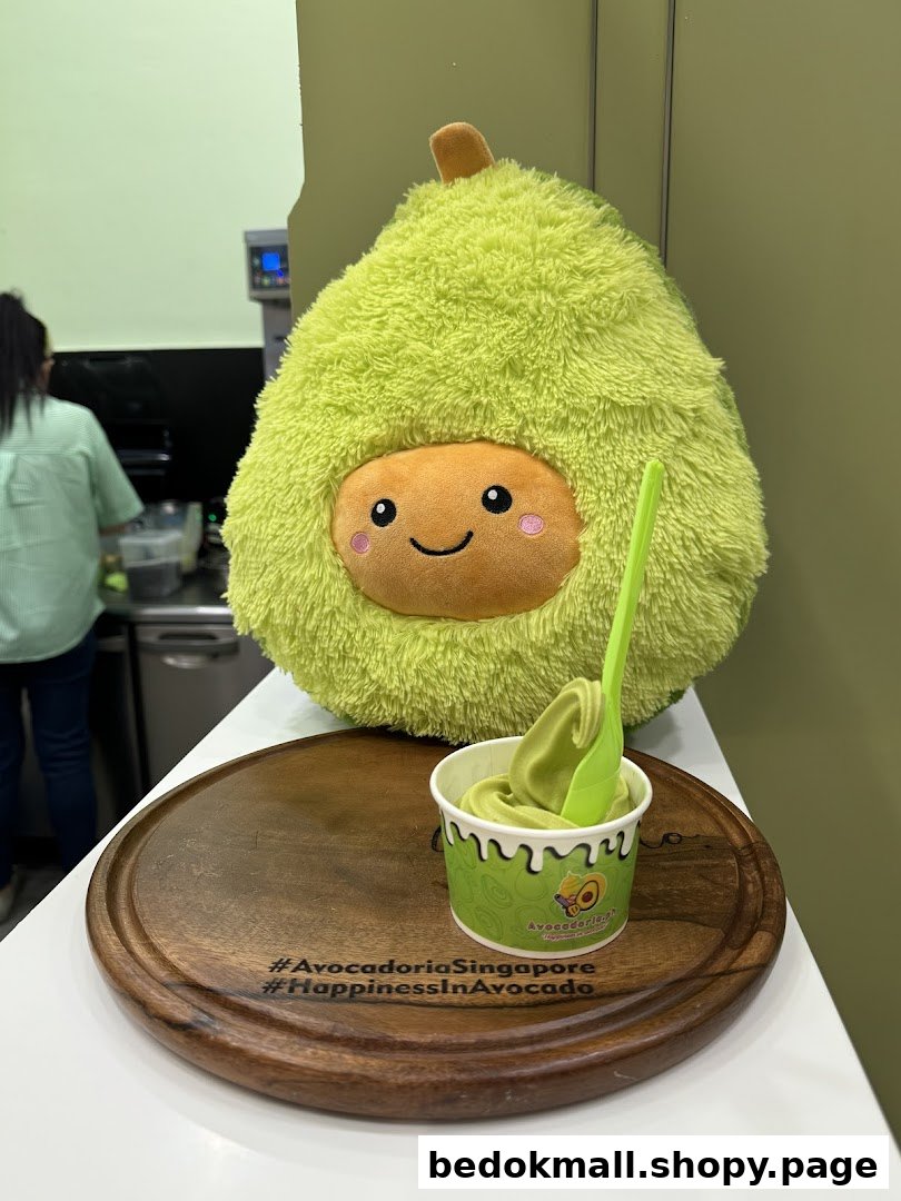 Avocado plushie and soft serve cup on a wooden tray inside the shop.