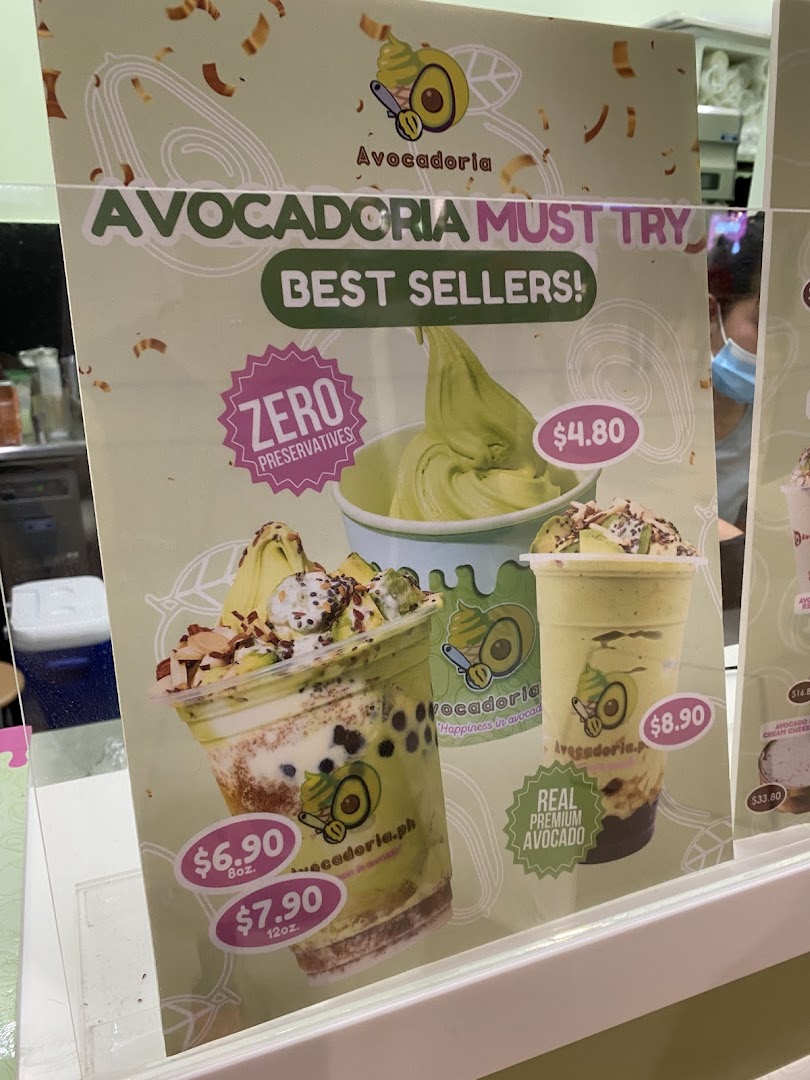 A menu board displaying avocado-based drinks and desserts with prices.