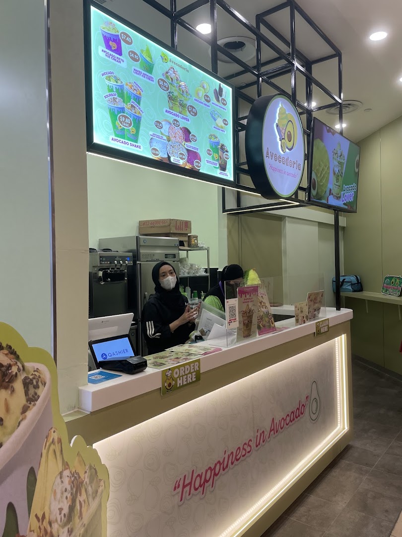 Shop interior with staff at counter and large digital menu.