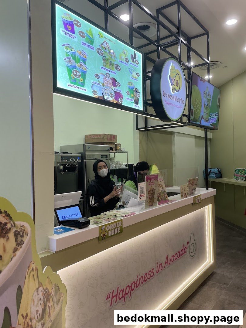Shop interior with staff at counter and large digital menu.