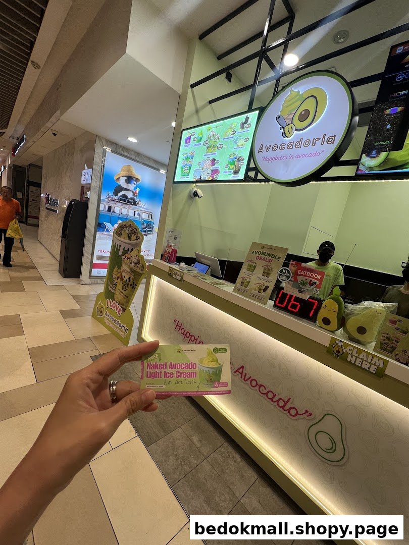 Interior shot of Avocadoria counter with signage and a person holding a card.