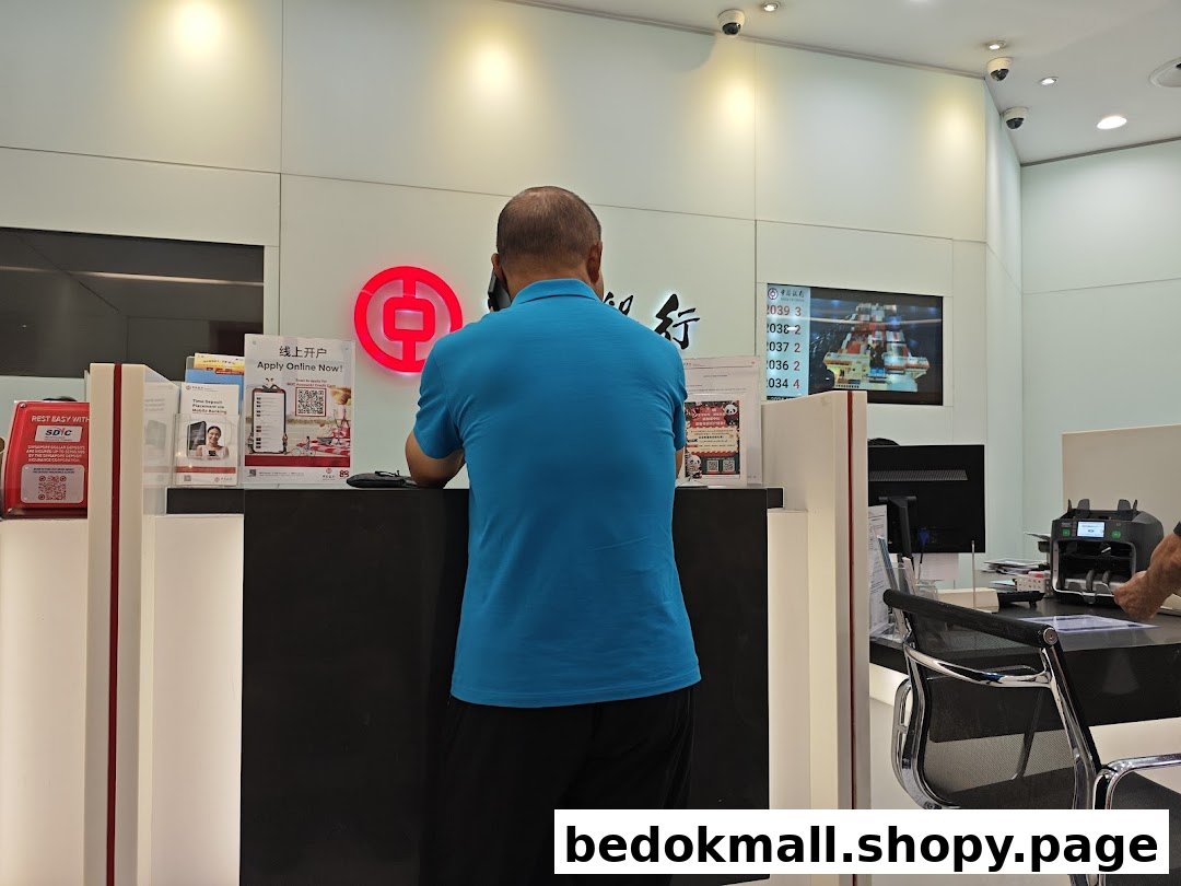 A person stands at a bank counter with the Bank of China logo visible.