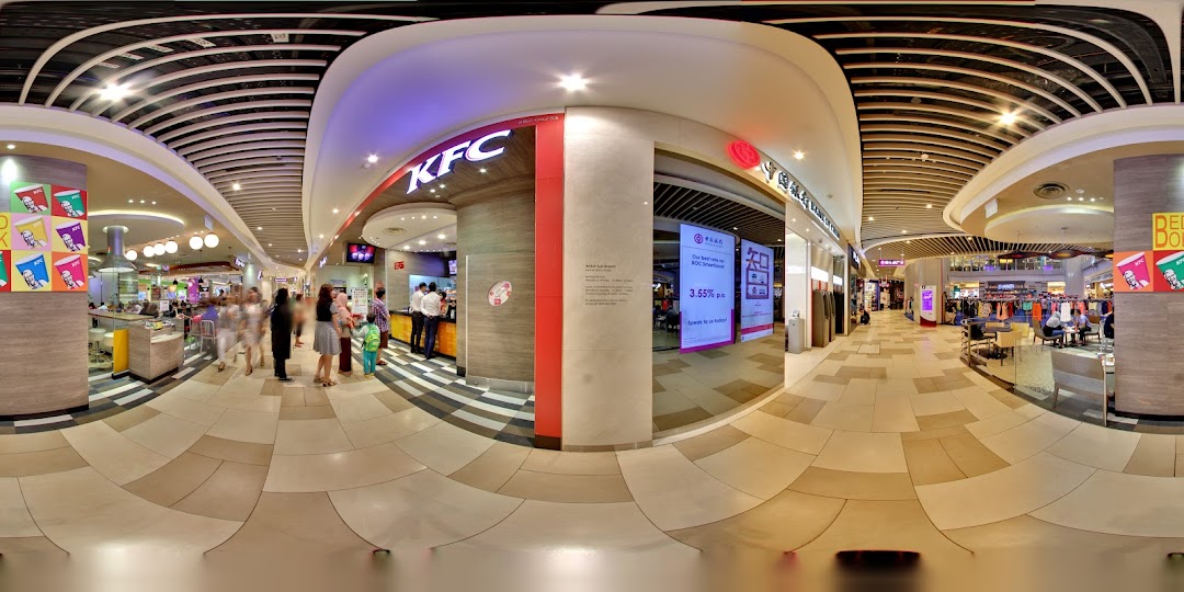 Interior view of a bustling shopping mall with various shops and people.