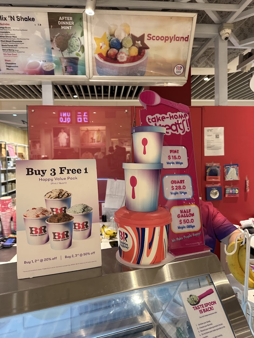 Interior view of an ice cream shop counter with menus and promotional displays.