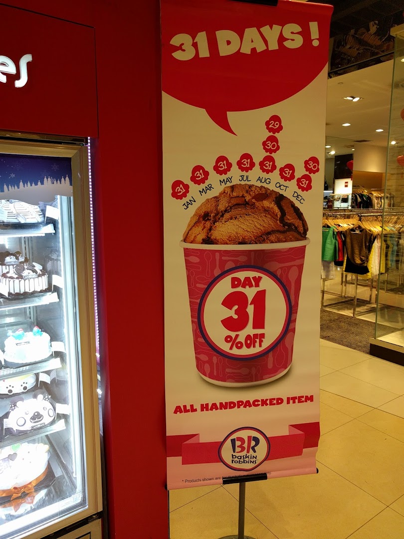 A Baskin-Robbins promotional banner for a '31 Days' discount, next to a cake display.