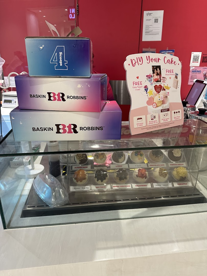Interior view of Baskin-Robbins counter with ice cream display and product boxes.