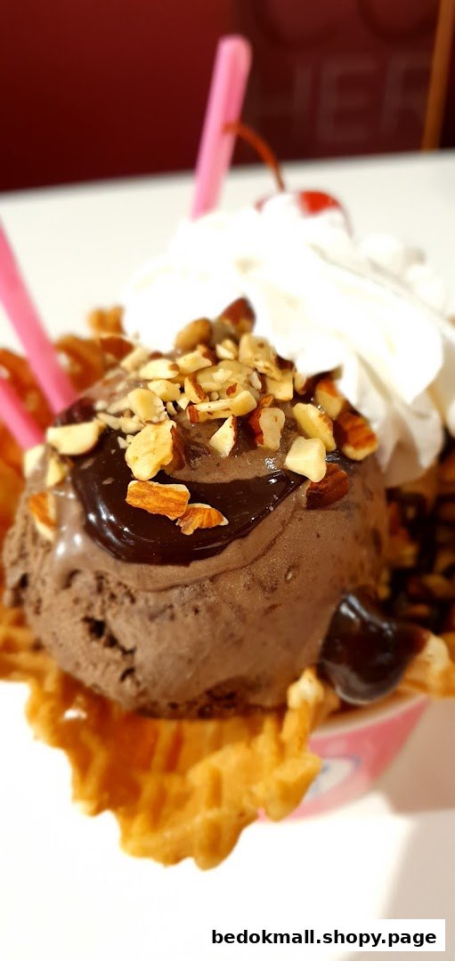 Close-up of chocolate ice cream sundae with nuts, whipped cream, and cherry.