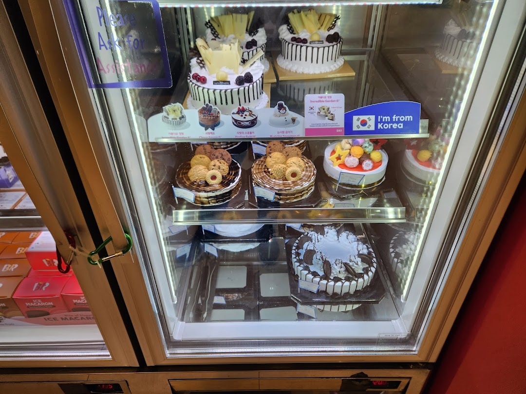 A refrigerated display case showcasing various cakes and desserts.