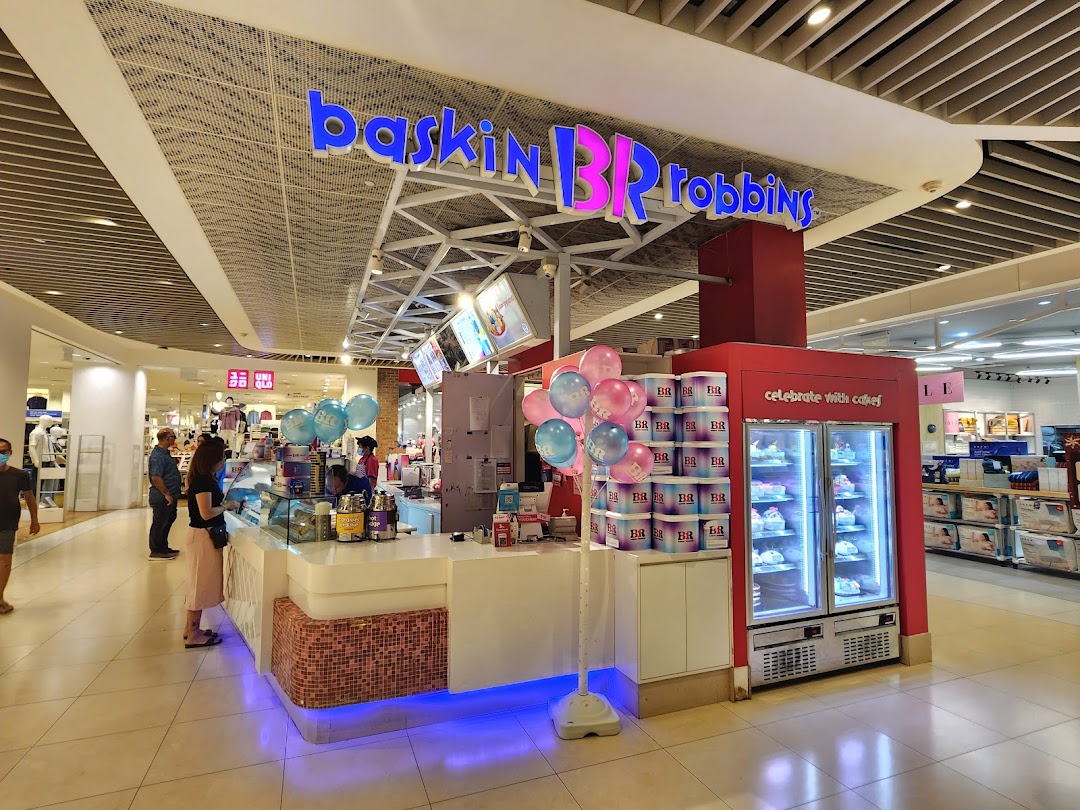 Interior view of a Baskin-Robbins kiosk with counter, cakes, and customers.