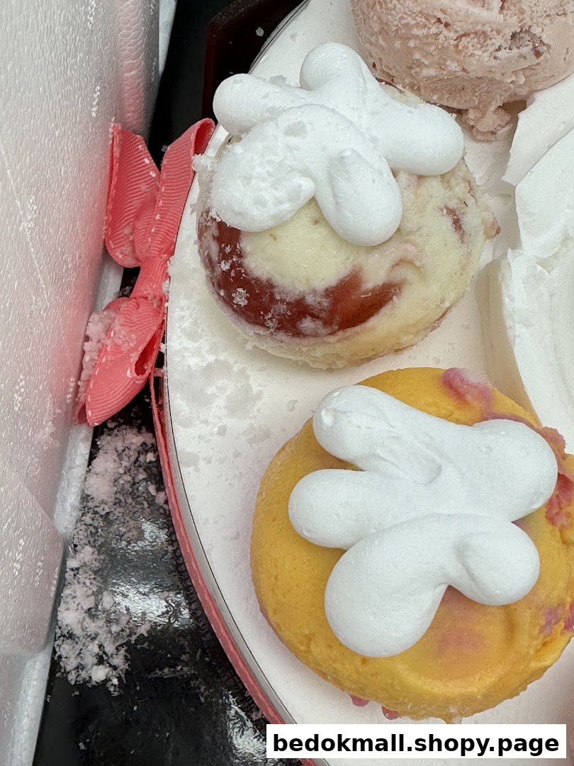 Two round desserts with white frosting and a pink ribbon.