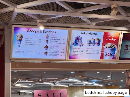 Digital menu boards display ice cream scoops, sundaes, and take-home options with prices.