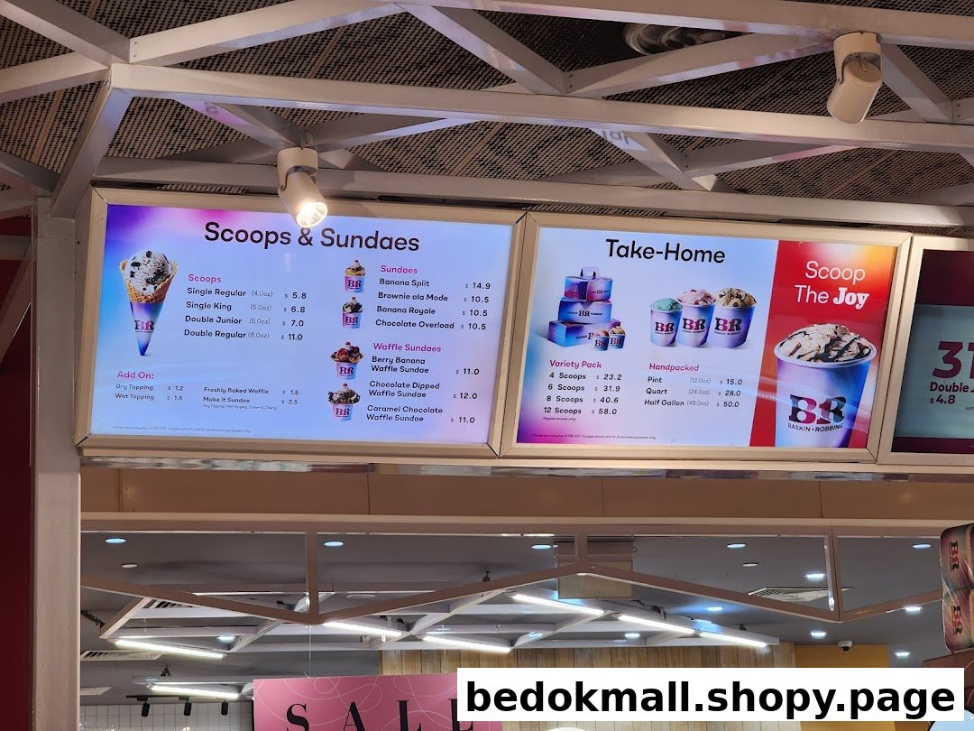 Digital menu boards display ice cream scoops, sundaes, and take-home options with prices.