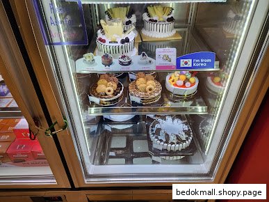 A refrigerated display case filled with various cakes.