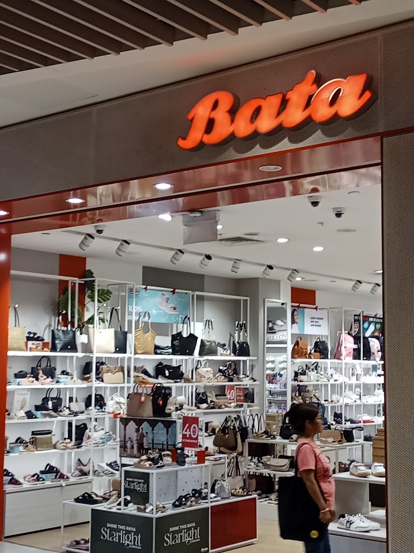 The image shows the illuminated Bata shop front with shoes and bags visible inside.