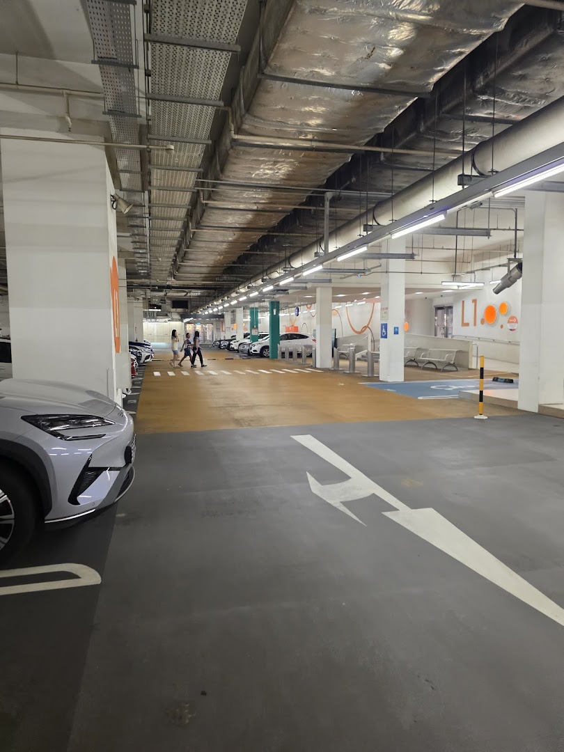 Indoor car park entrance with vehicles, pedestrians, and floor markings.