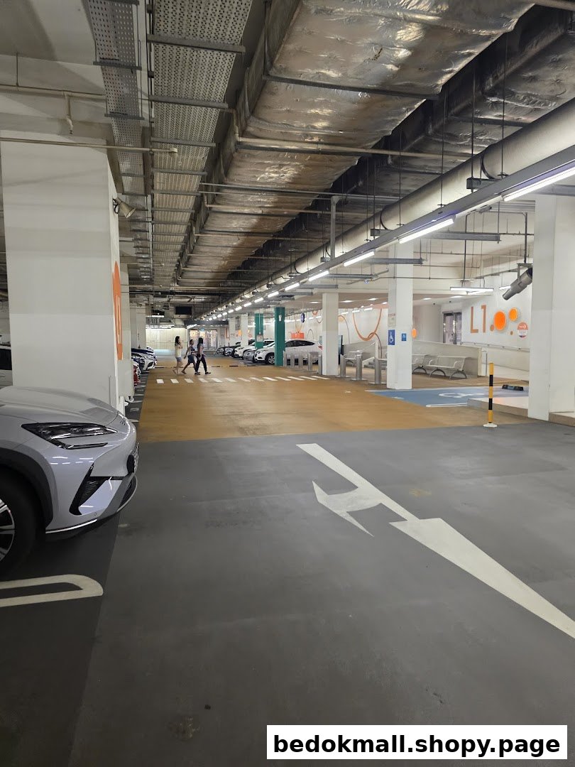 Indoor car park entrance with vehicles, pedestrians, and floor markings.