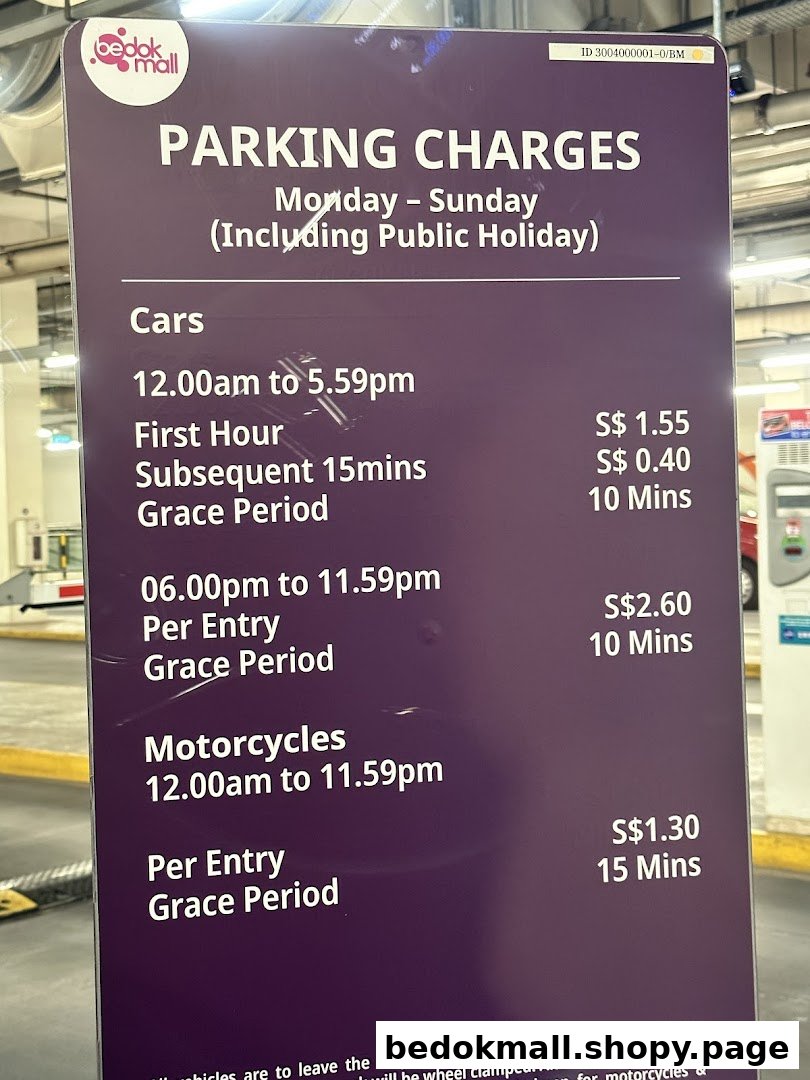 A sign displaying parking charges for cars and motorcycles at Bedok Mall.