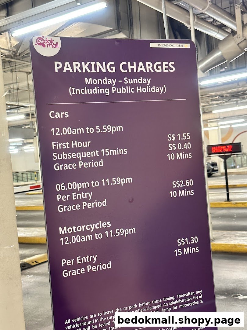 A sign displaying parking charges for cars and motorcycles at Bedok Mall.