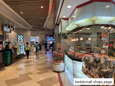 Interior view of a shop counter displaying products in a busy mall walkway.