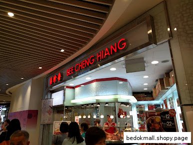The entrance of Bee Cheng Hiang shop with visible signage, staff, and products.