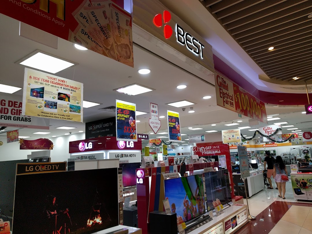 Interior view of an electronics store with TVs and promotional signs.