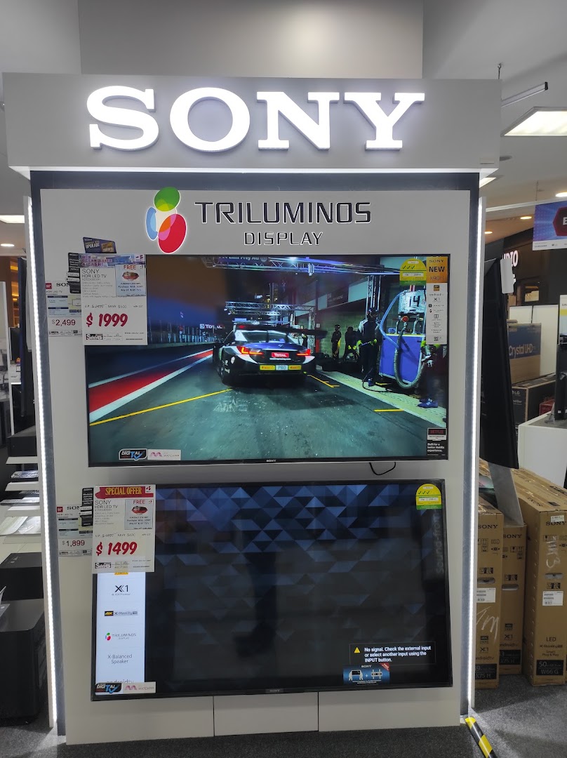 Sony TV display stand with two televisions and product information in a store.