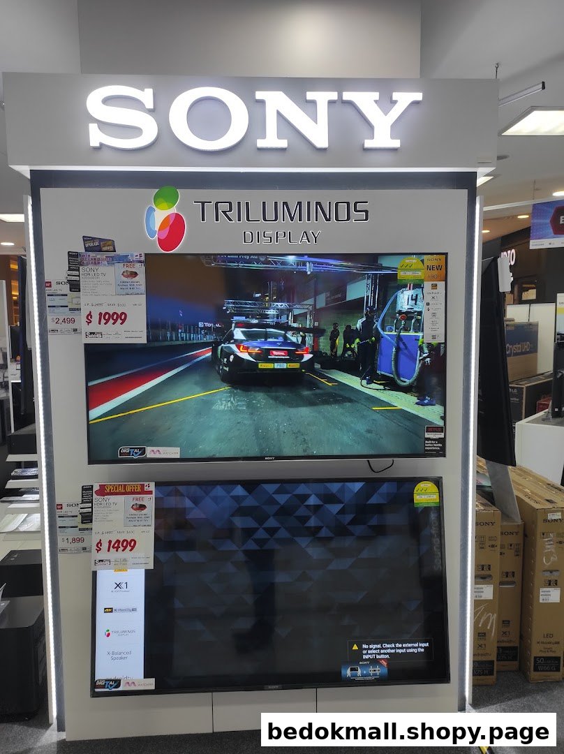 Sony TV display stand with two televisions and product information in a store.