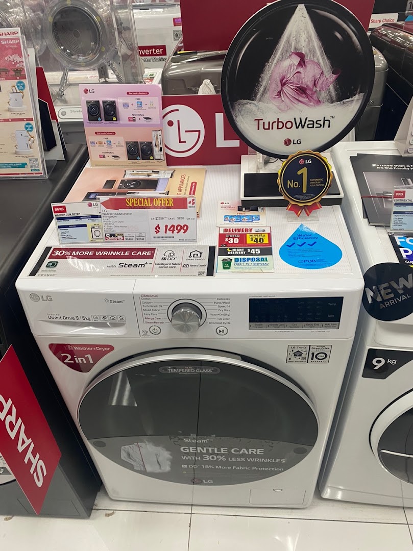 An LG washing machine on display with promotional signs in a retail store.