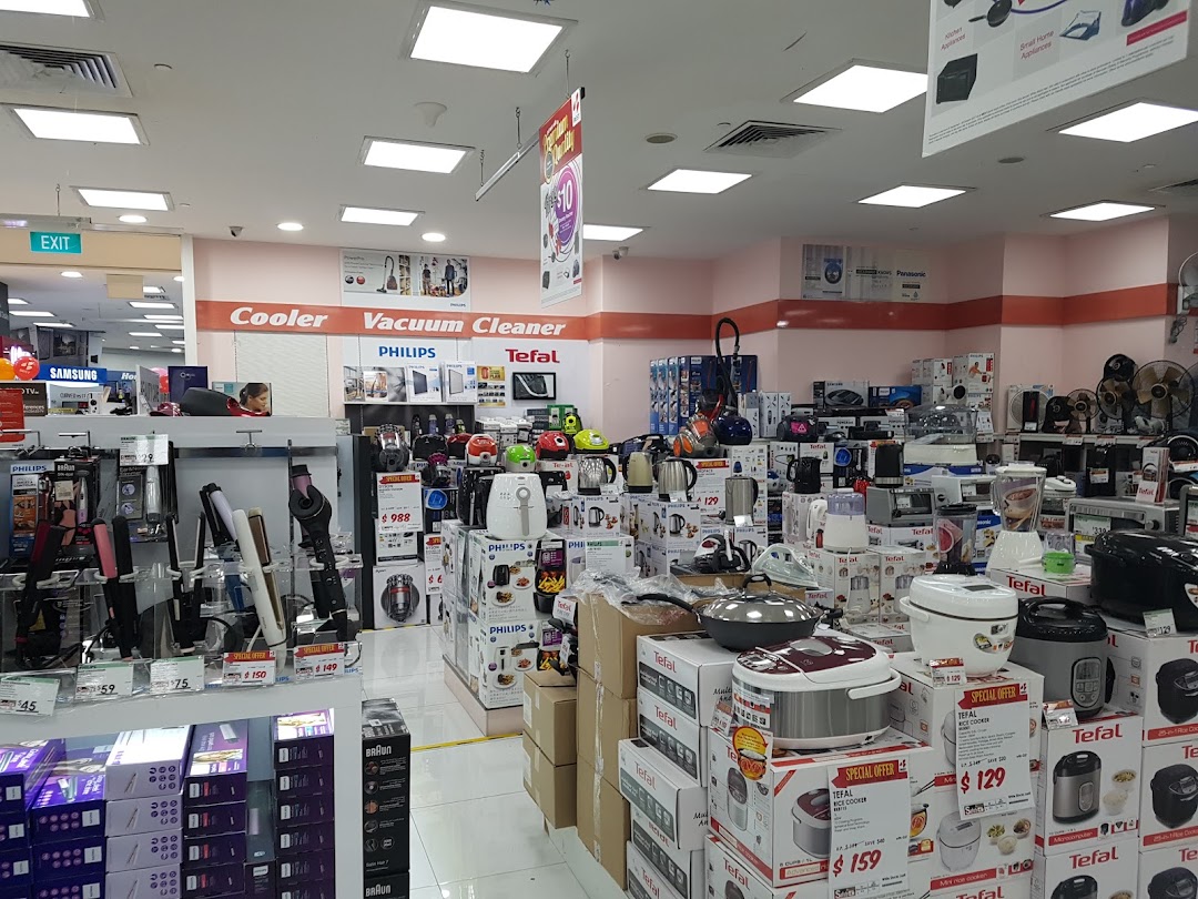 Interior of an electronics store displaying various home appliances and electronics.