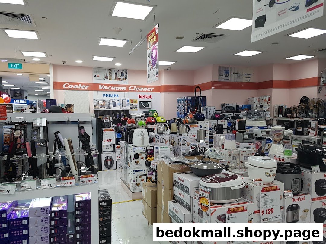 Interior of an electronics store displaying various home appliances and electronics.
