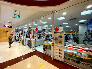 View of a shop's glass entrance from the mall corridor, showing interior displays.
