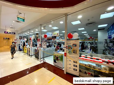 View of a shop's glass entrance from the mall corridor, showing interior displays.
