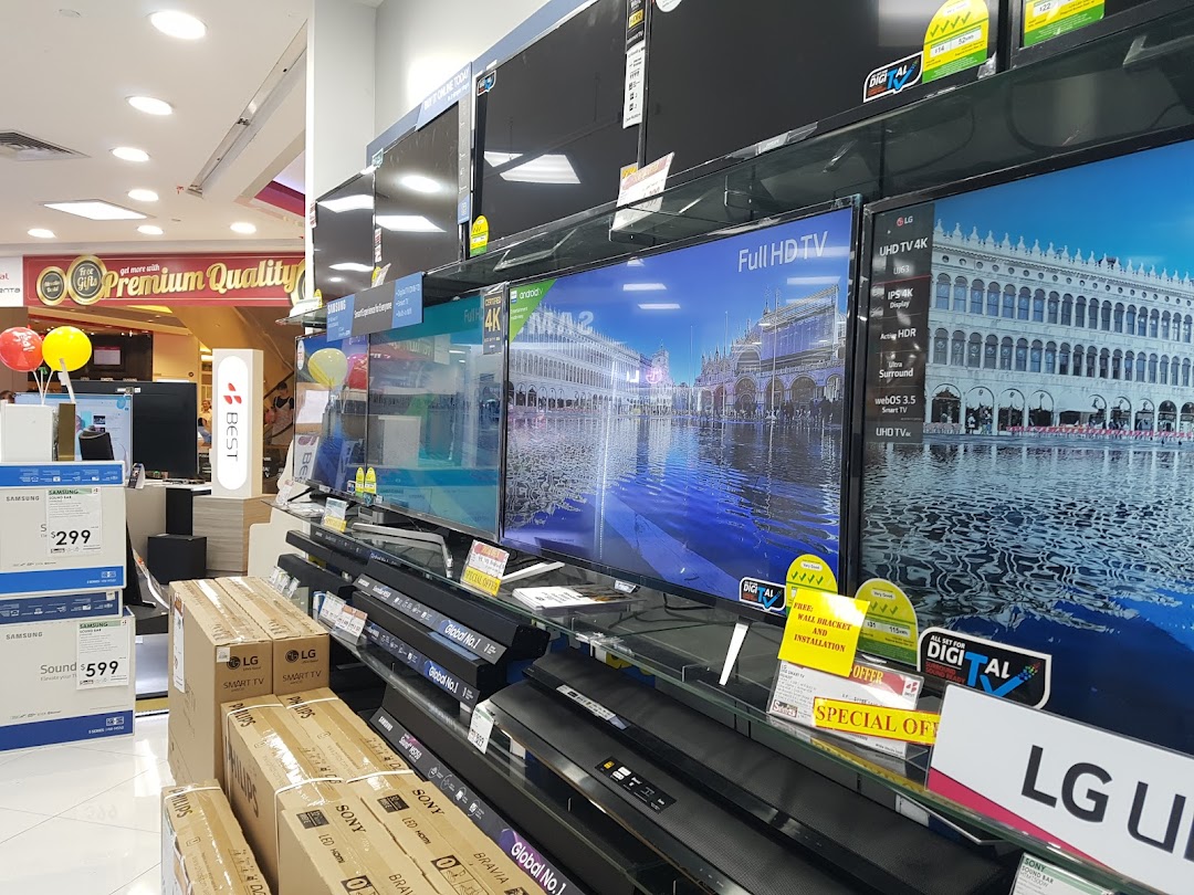 Interior of an electronics store displaying televisions, soundbars, and product boxes.